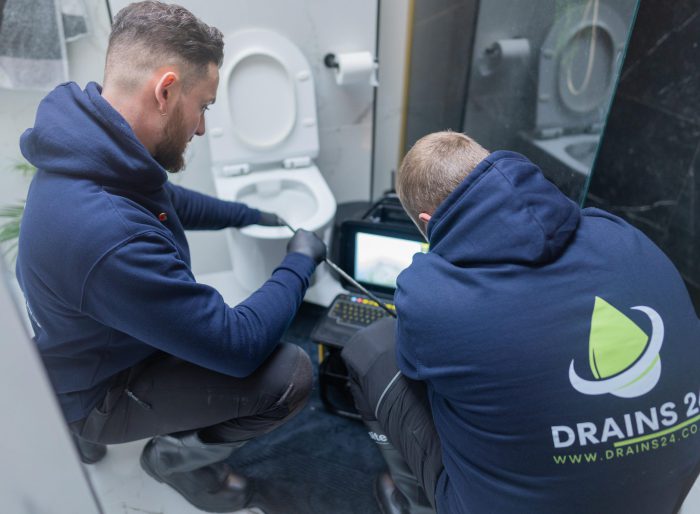 Drainage engineer assessing a blocked toilet and internal drainage problem in a Twickenham bathroom