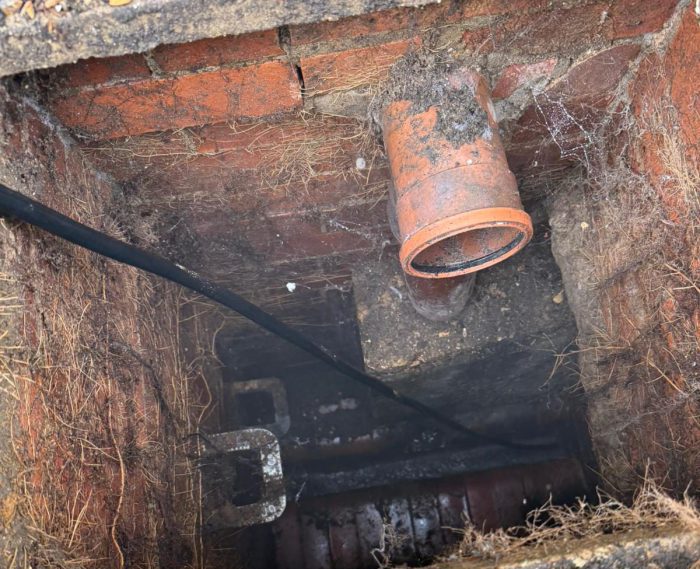 Blocked outside drain with standing water and debris causing poor drainage at a Twickenham property
