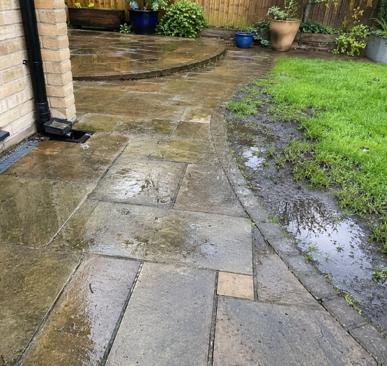 Standing surface water on a patio and garden showing signs of a failing soakaway at a Twickenham property