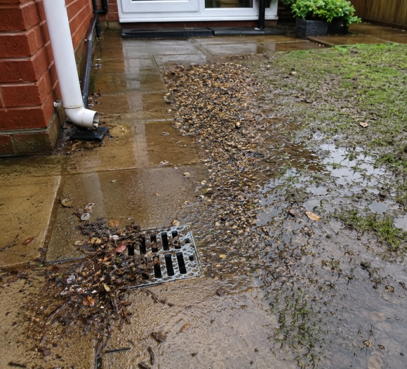 Blocked surface water drain with silt, debris and poor water dispersal causing soakaway problems at a Twickenham property