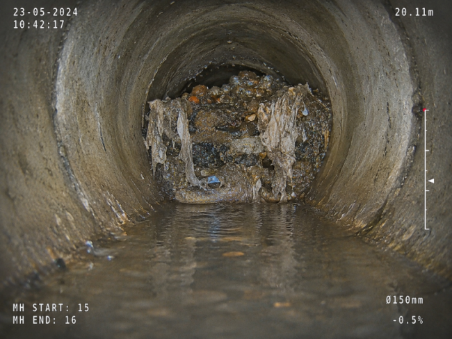 CCTV drain survey screen view showing a blocked drain pipe with standing water, debris and waste build-up during a Twickenham drainage inspection.